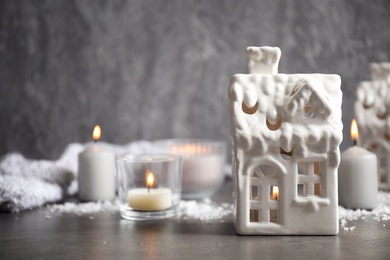Photo of Composition with house shaped candle holders on grey stone table, space for text. Christmas decoration