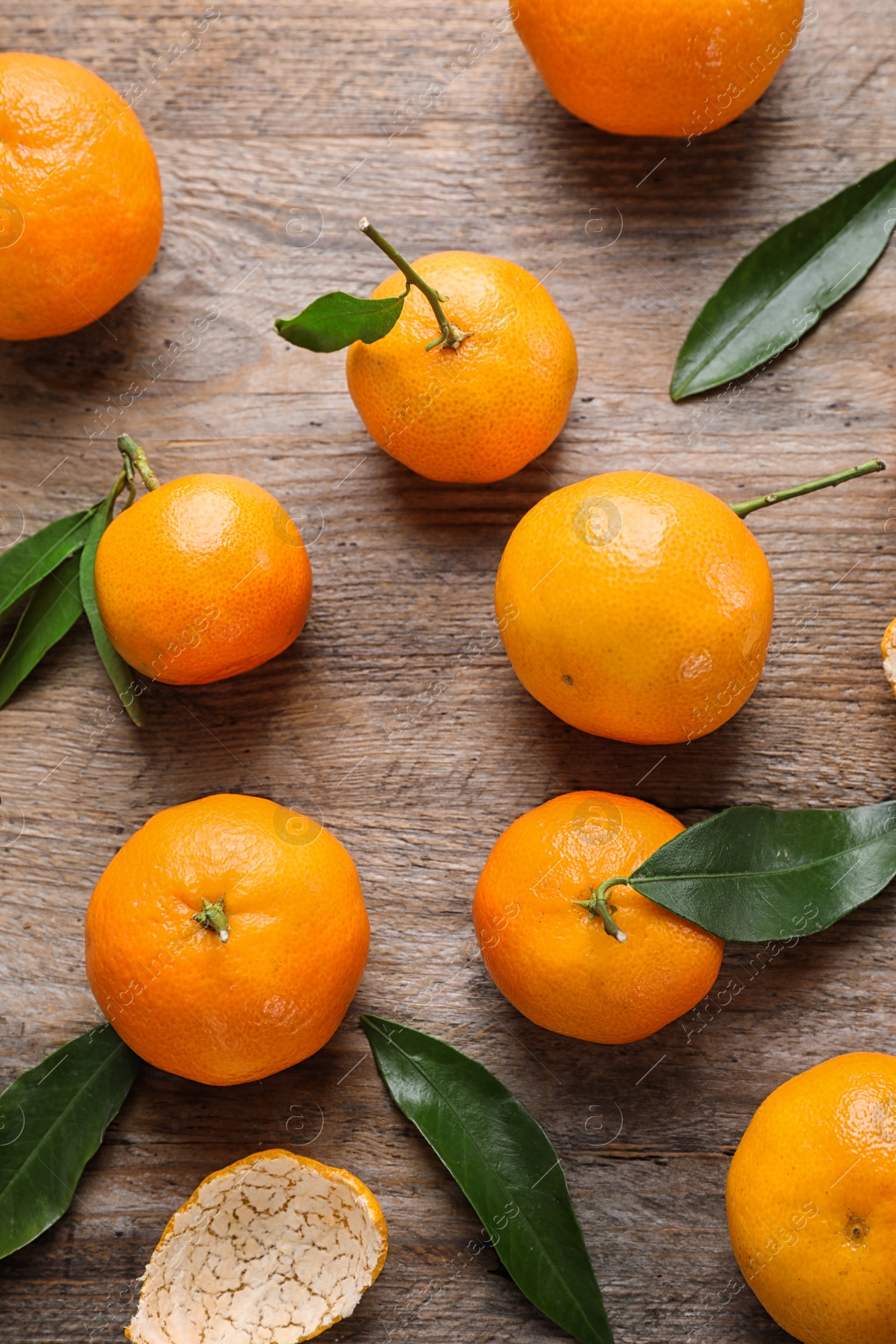 Photo of Fresh ripe tangerines on wooden table, flat lay