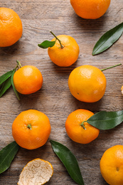 Photo of Fresh ripe tangerines on wooden table, flat lay