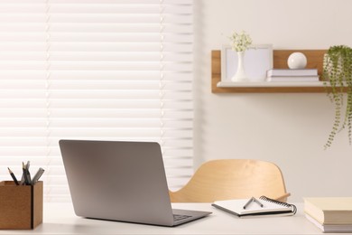 Home office. Laptop and stationery on white desk indoors. Space for text