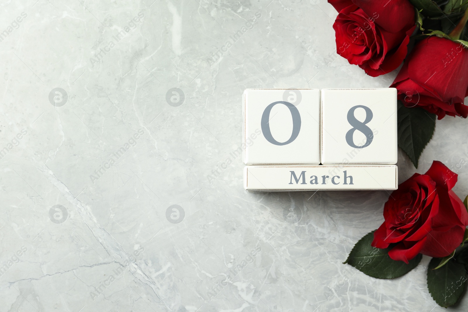 Photo of Block calendar with date 8th of March and roses on light grey marble background, flat lay. Space for text