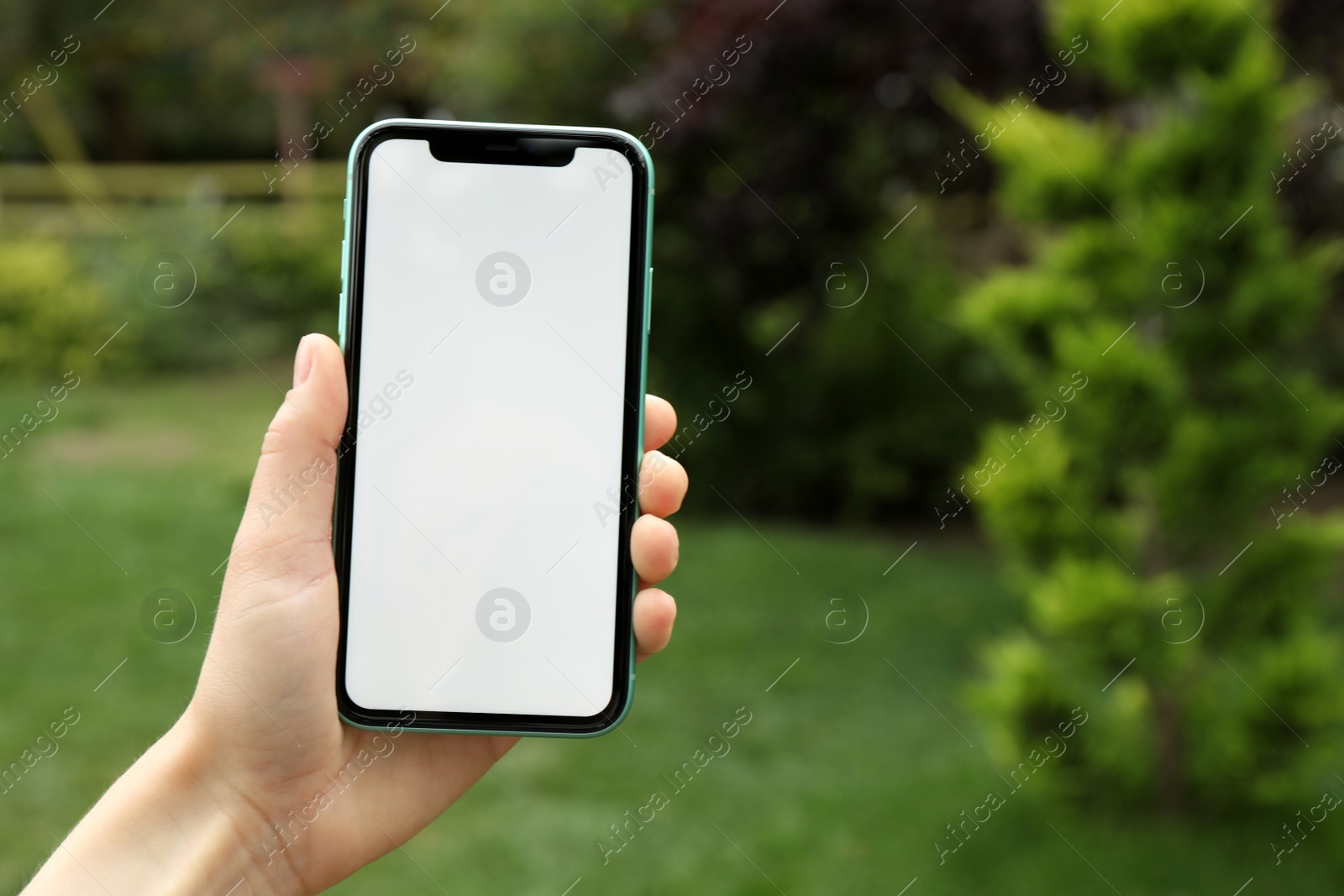 Photo of MYKOLAIV, UKRAINE - JULY 8, 2020: Woman holding Iphone 11 Pro Max with blank screen outdoors, closeup. Space for text