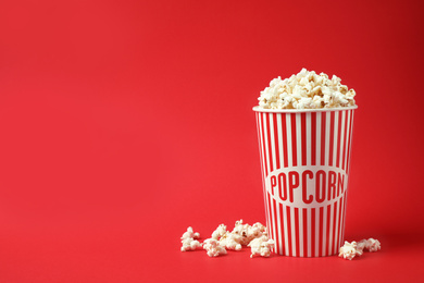 Photo of Delicious popcorn on red background. Space for text