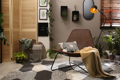 Lounge area interior with comfortable armchair and beautiful houseplants