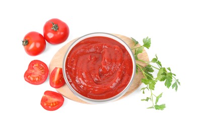 Photo of Organic ketchup in bowl, fresh tomatoes and parsley isolated on white, top view. Tomato sauce