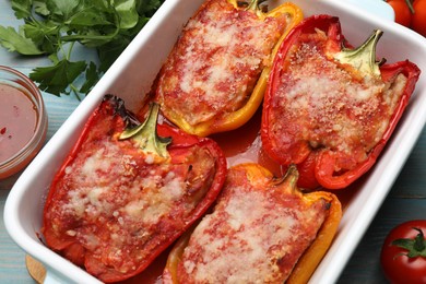 Photo of Tasty stuffed peppers in dish and ingredients on table, flat lay