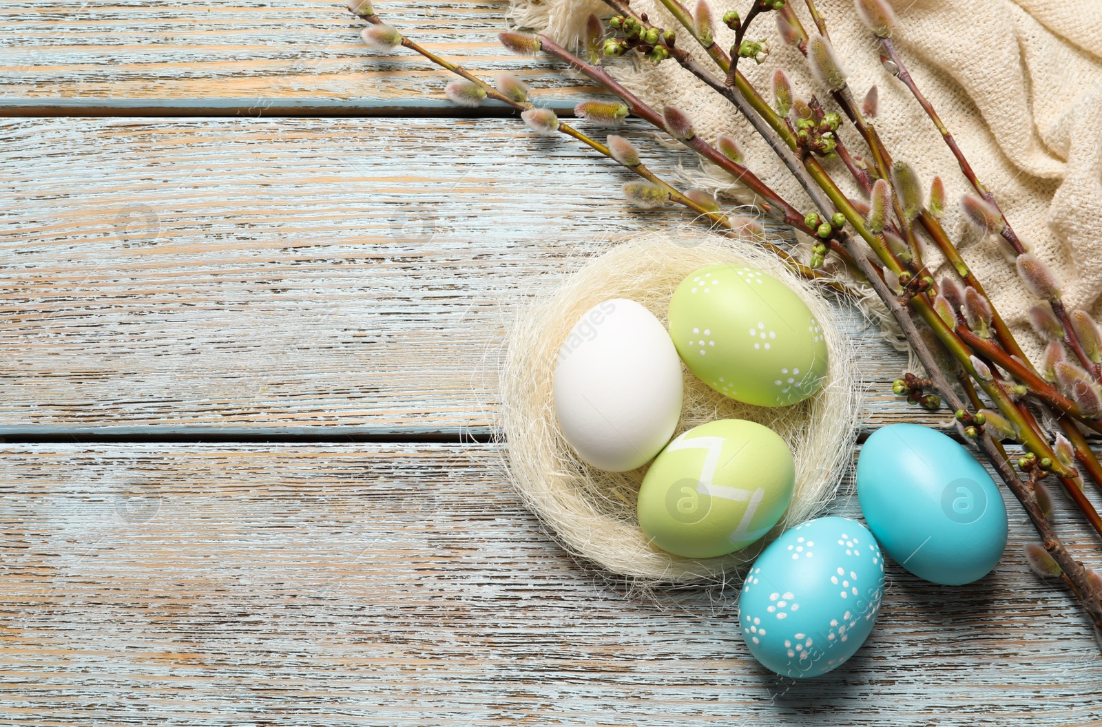 Photo of Flat lay composition with painted Easter eggs on wooden table, space for text