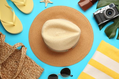 Flat lay composition with straw hat on turquoise background