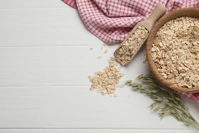 Photo of Oatmeal and branches with florets on white wooden table, flat lay. Space for text