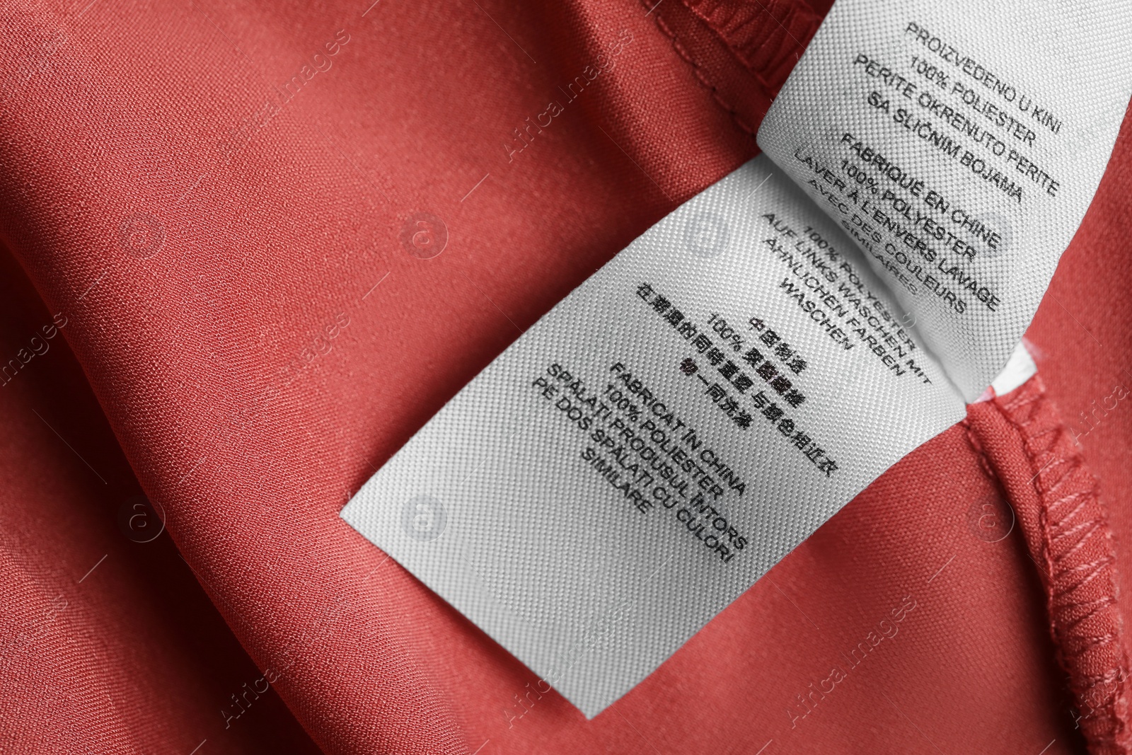 Photo of Clothing labels on beautiful garment, top view. Space for text