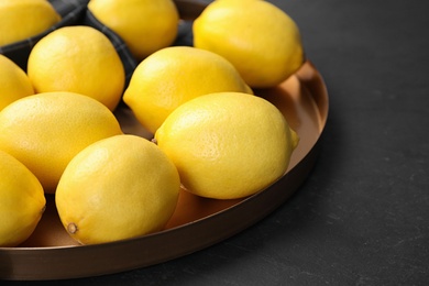 Photo of Fresh ripe lemons on dark table, closeup