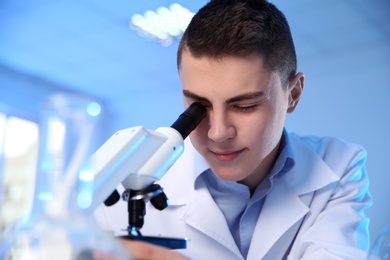 Photo of Male scientist using modern microscope in chemistry laboratory