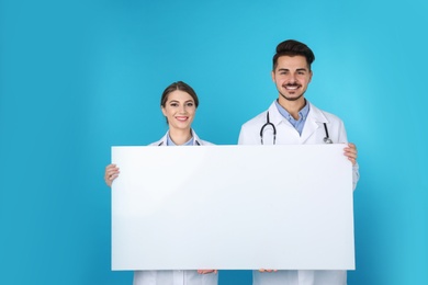Photo of Medical students with blank poster on color background. Space for text