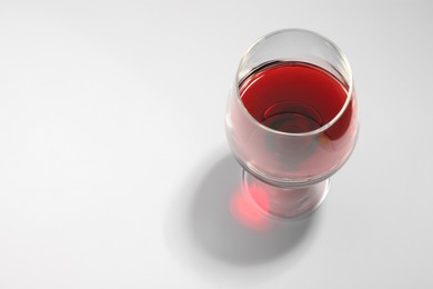 Photo of Tasty red wine in glass isolated on white, above view