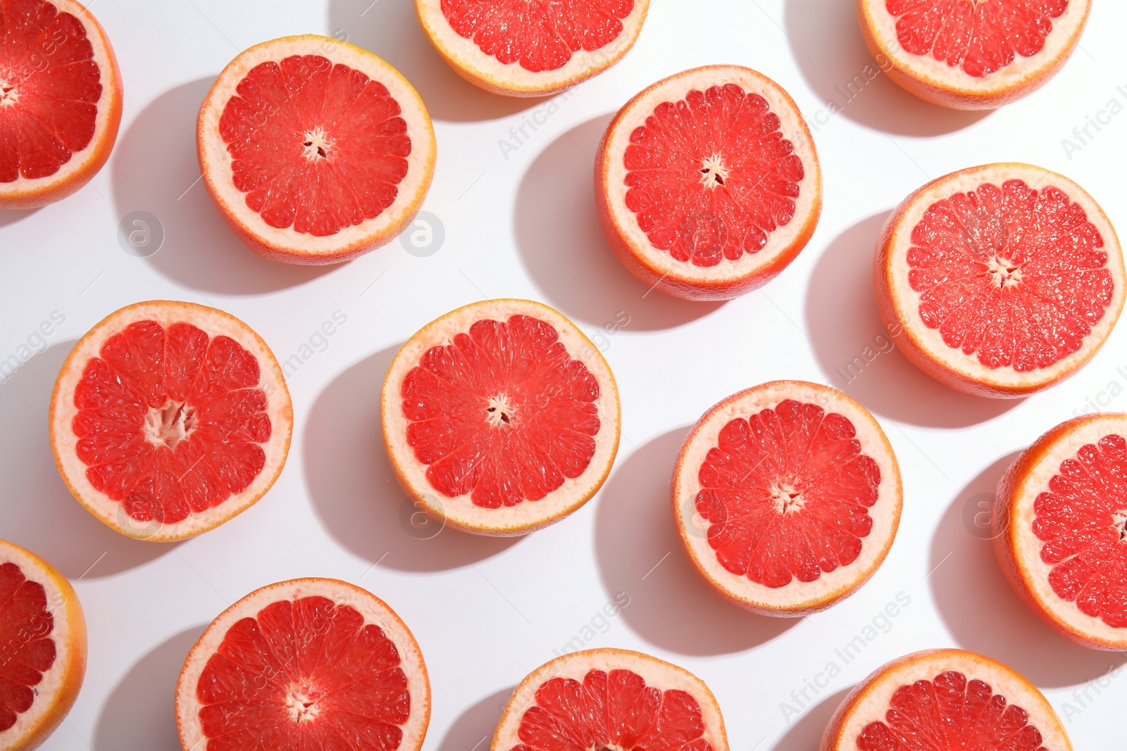 Photo of Fresh sliced ripe grapefruits on white background, top view