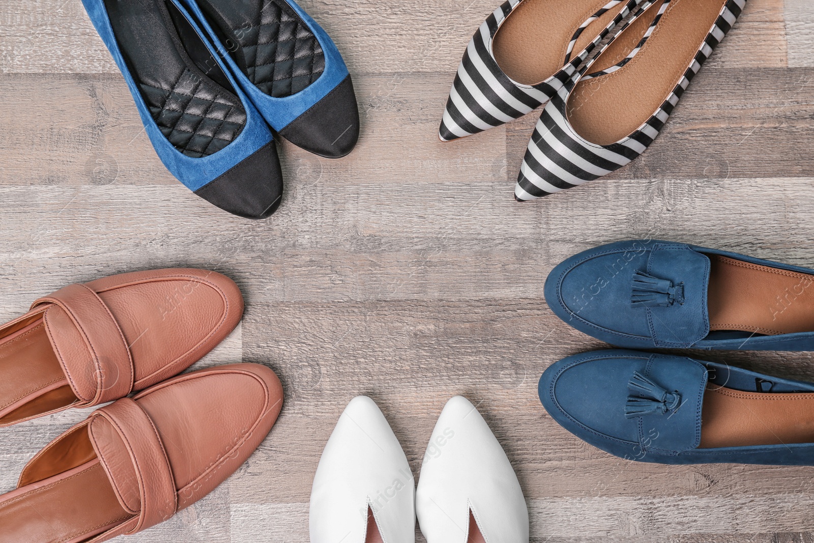 Photo of Different female shoes on wooden background, top view