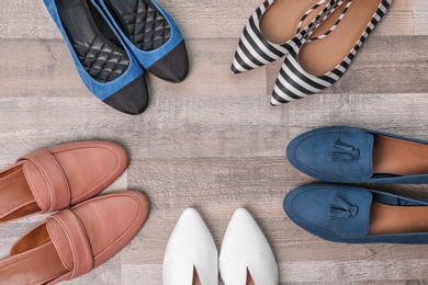 Photo of Different female shoes on wooden background, top view