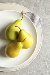 Photo of Plate with ripe pears on light background, top view