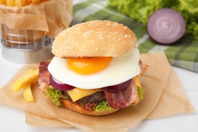 Photo of Delicious burger with fried egg on white table, closeup