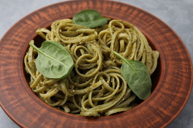 Tasty pasta with spinach on grey table, closeup