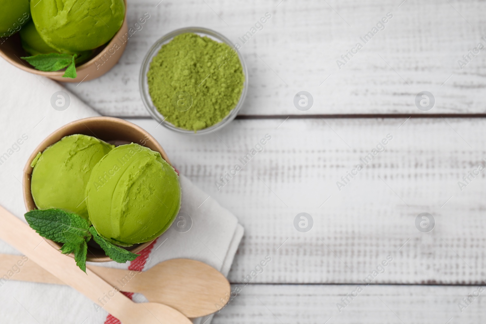 Photo of Paper cups with tasty matcha ice cream on white wooden table, flat lay. Space for text