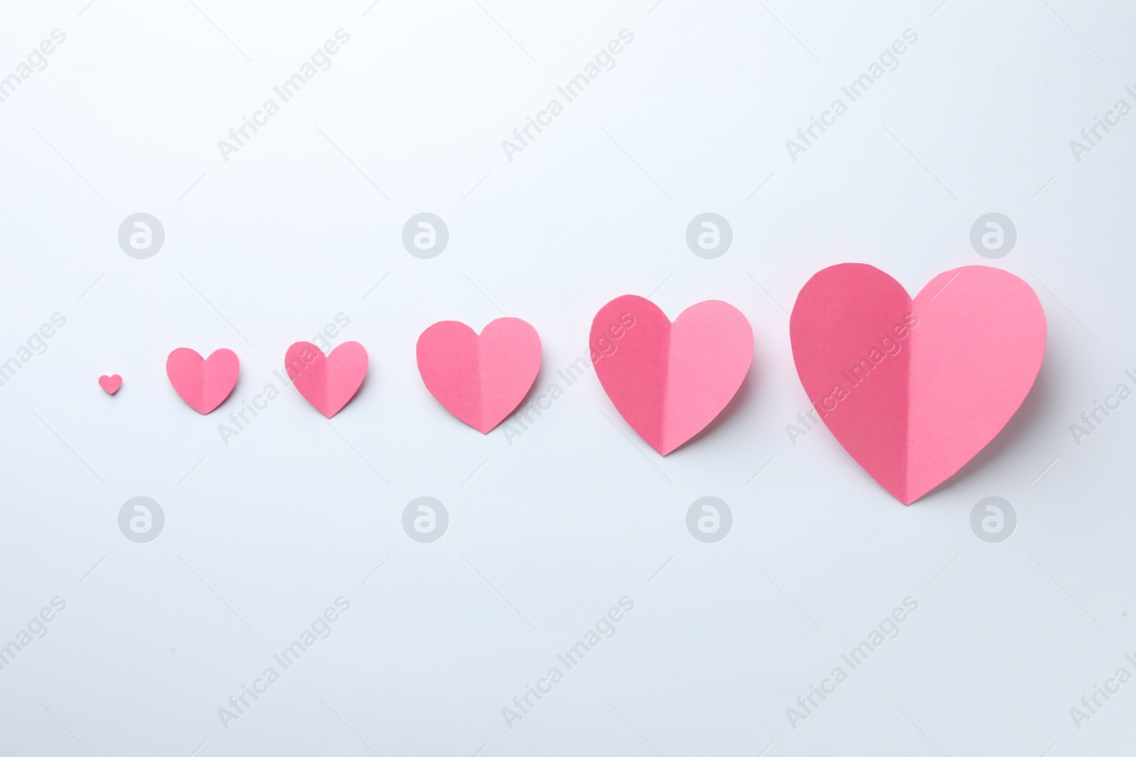 Photo of Pink paper hearts on white background, flat lay