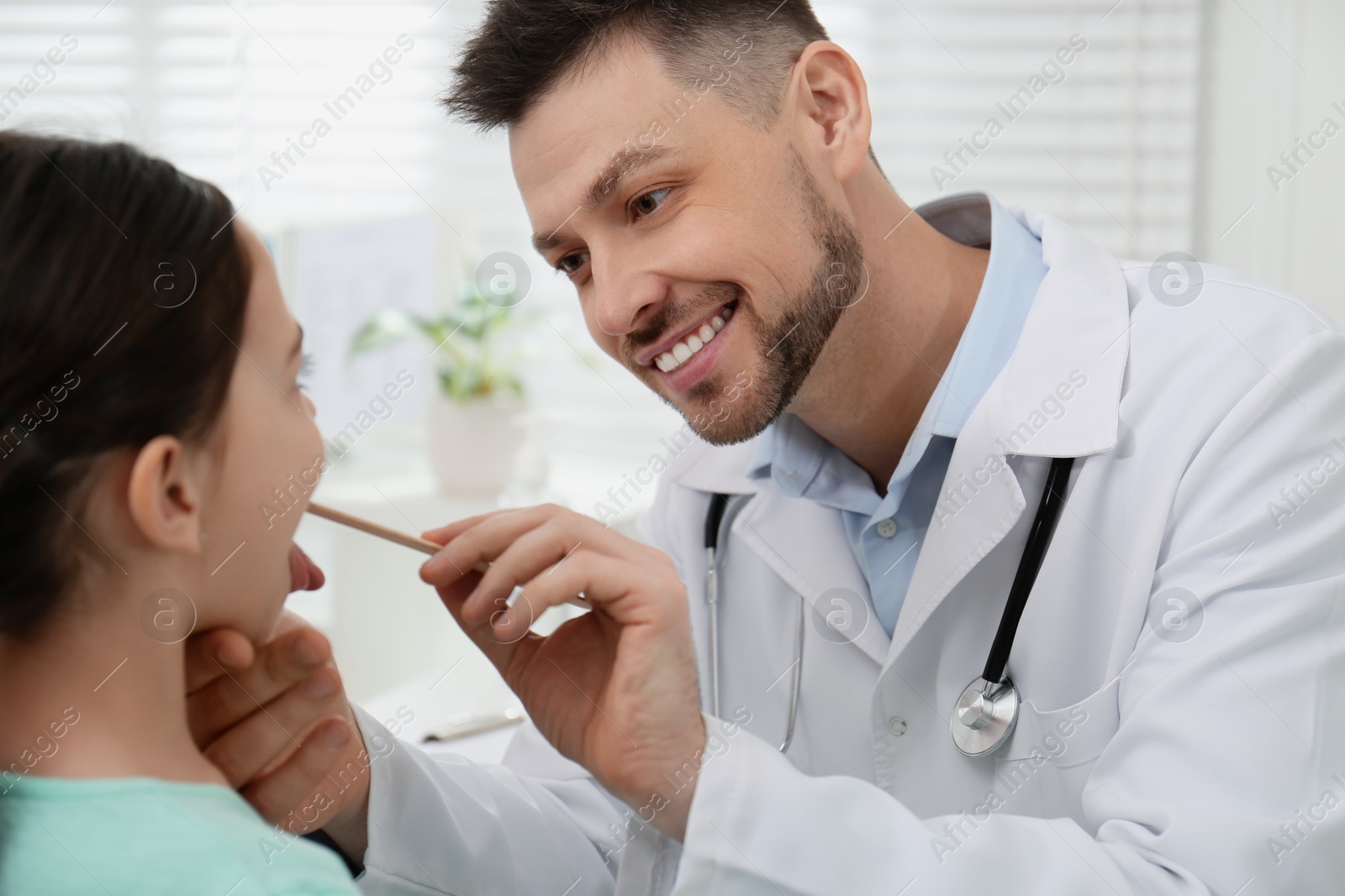 Photo of Pediatrician examining little girl in office at hospital