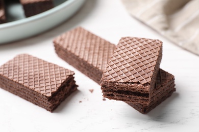 Photo of Delicious chocolate wafers on white table, closeup