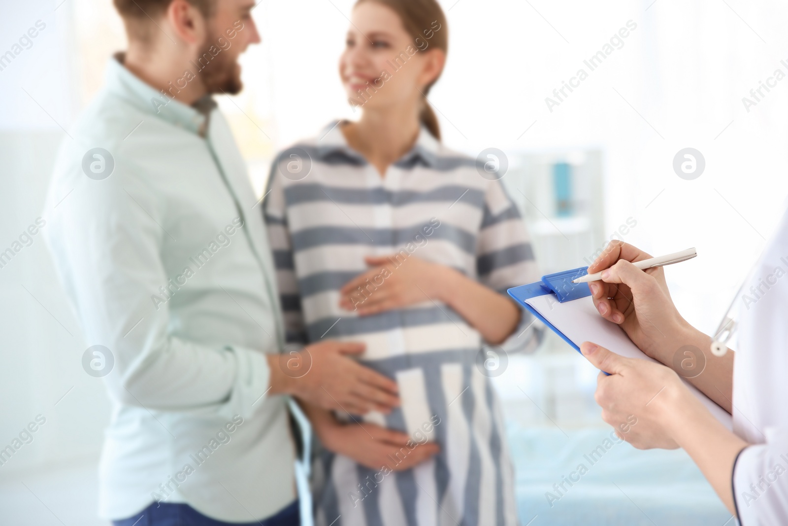 Photo of Gynecology consultation. Future parents with doctor in hospital