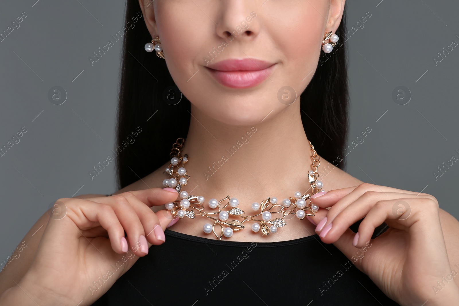 Photo of Young woman with elegant jewelry on dark grey background, closeup