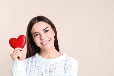 Photo of Portrait of young woman with decorative red heart on color background