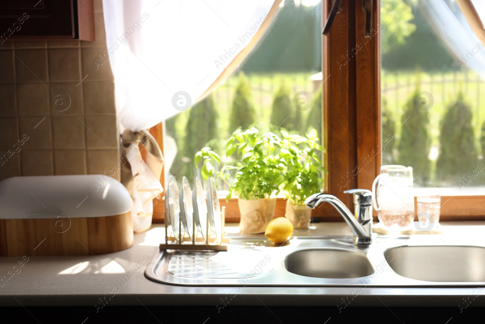 Photo of Holder with plates near sink in kitchen