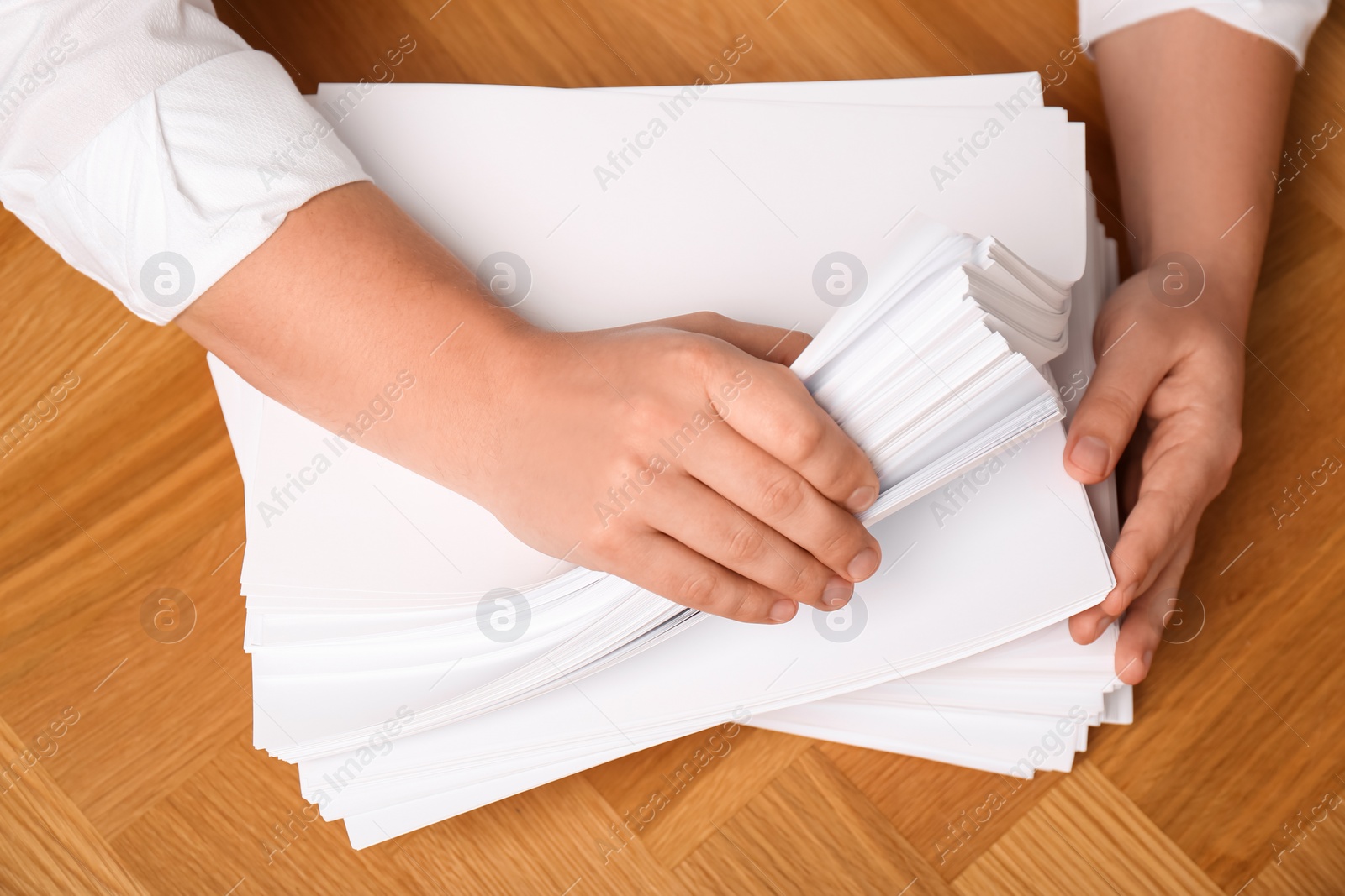 Photo of Man stacking documents at wooden table, top view