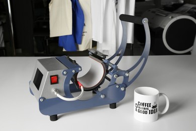Photo of Printing logo. Heat press and cup on white table