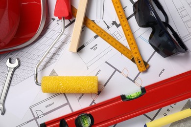 Photo of Flat lay composition with building level and other construction tools on papers