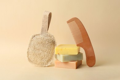 Photo of Natural loofah, bamboo hair comb and soap bars on beige background. Conscious consumption