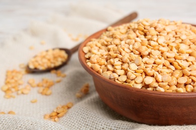 Photo of Bowl and spoon with dried peas on fabric