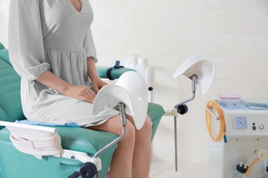 Gynecological checkup. Woman sitting on examination chair in hospital, closeup