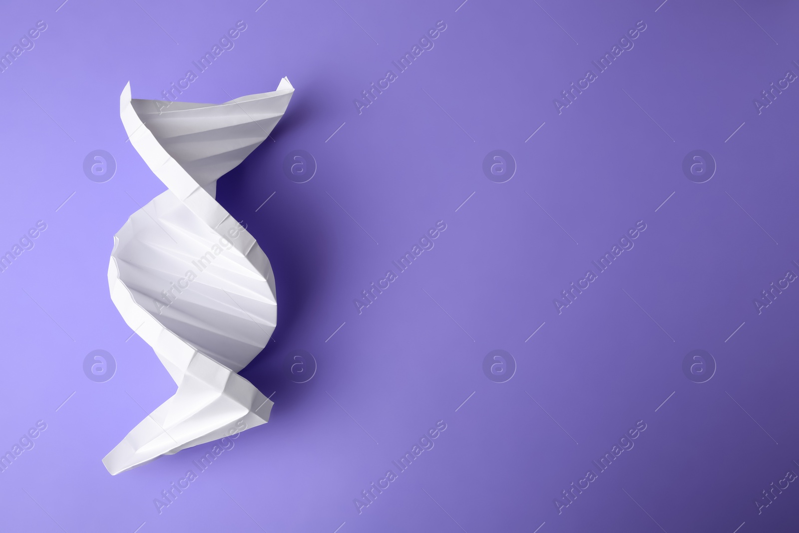 Photo of Paper model of DNA molecular chain on violet background, top view. Space for text
