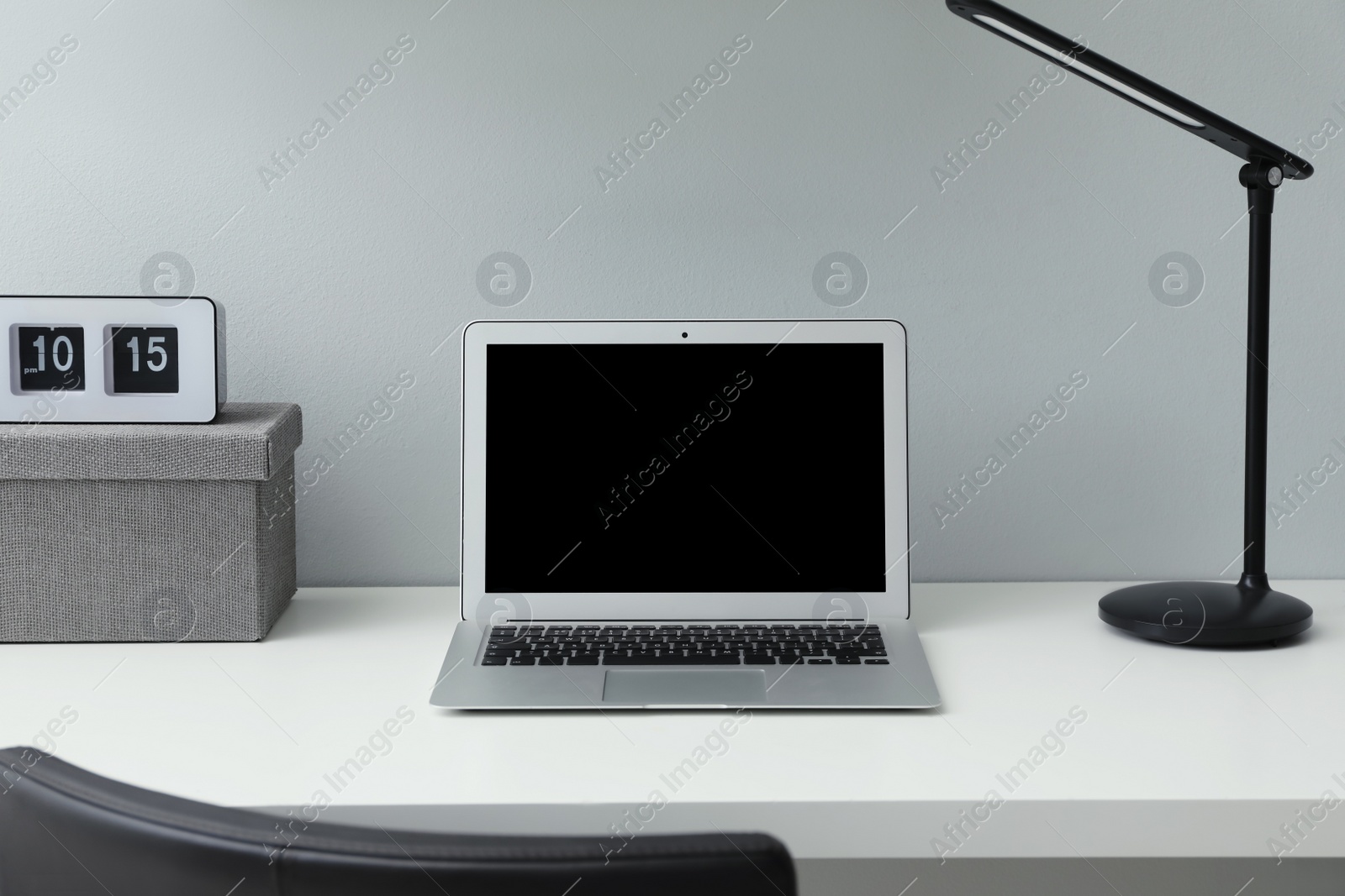 Photo of Modern laptop on white office desk indoors. Comfortable workplace