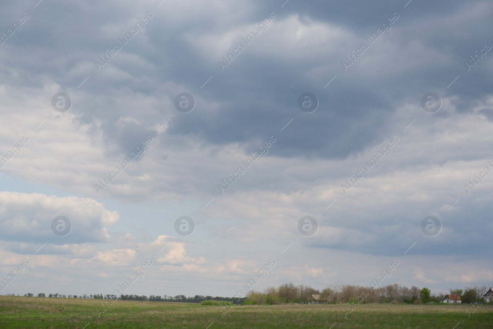 Photo of Houses under cloudy sky. Picturesque rural landscape