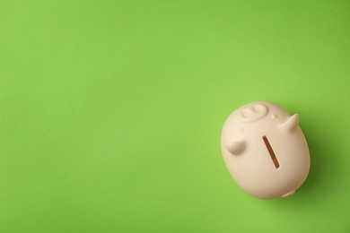 Cute piggy bank on color background, top view