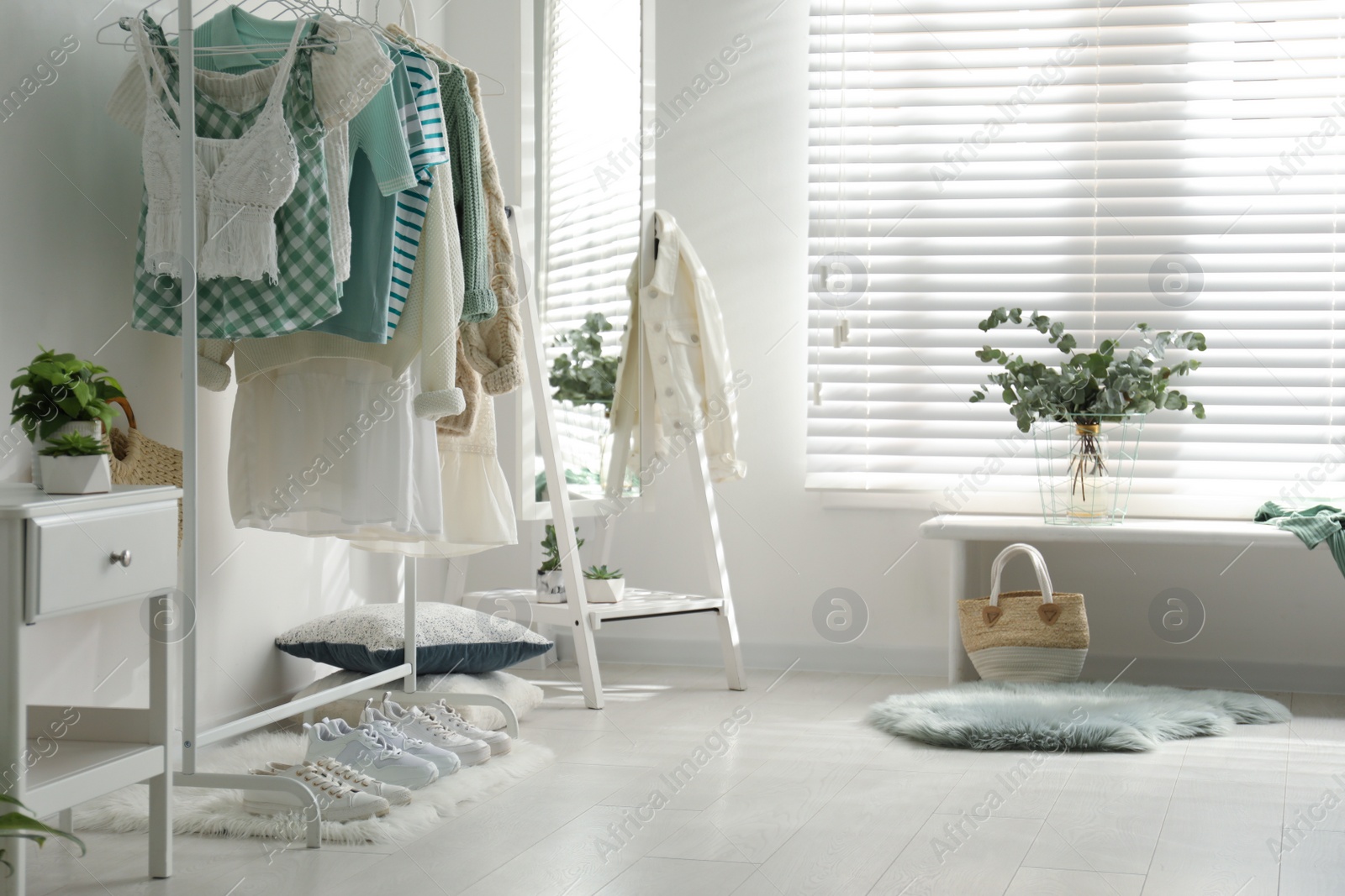 Photo of Dressing room interior with clothing rack and mirror