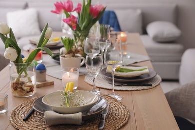 Photo of Beautiful Easter table setting with beautiful flowers indoors