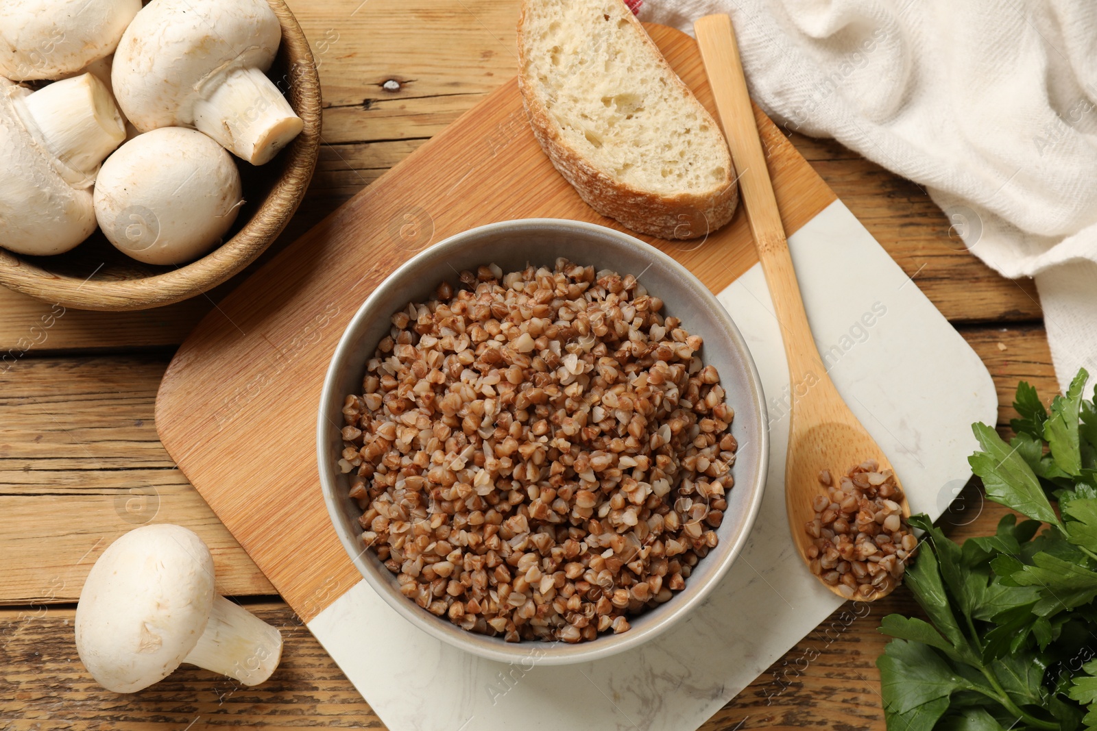 Photo of Tasty buckwheat in bowl on wooden table, flat lay