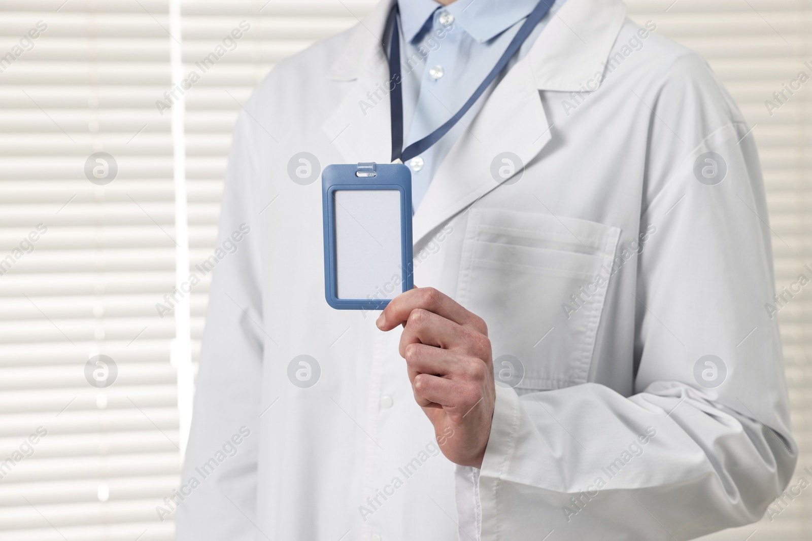 Photo of Doctor showing empty badge in hospital, closeup