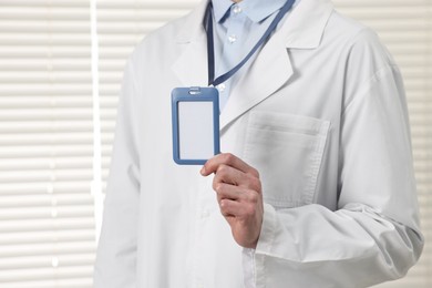 Photo of Doctor showing empty badge in hospital, closeup