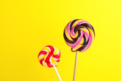 Different bright yummy candies on color background