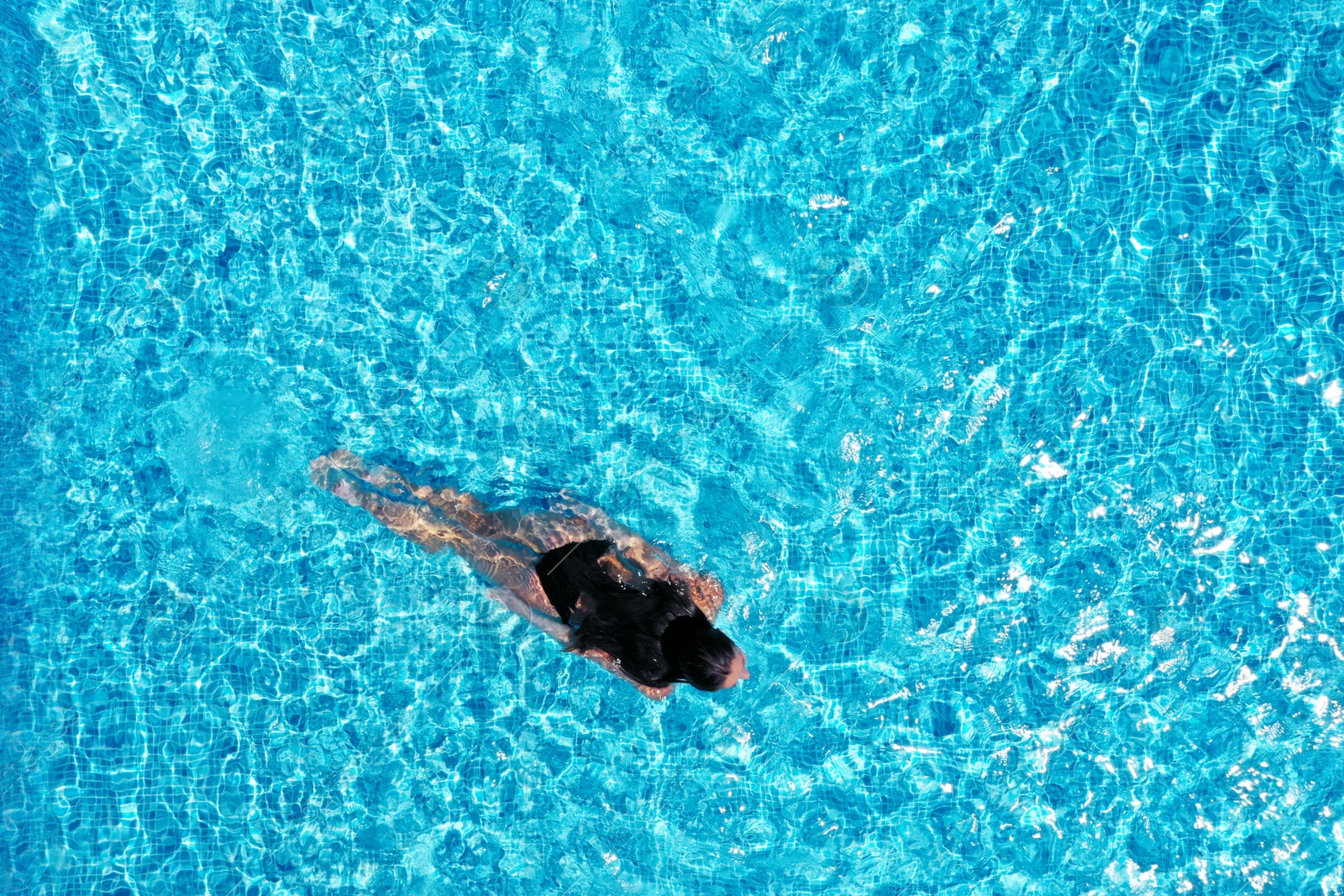 Image of Beautiful young woman swimming in pool, top view. Space for text