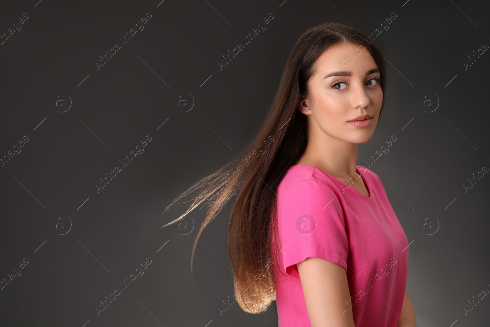 Photo of Portrait of beautiful young woman on dark grey background